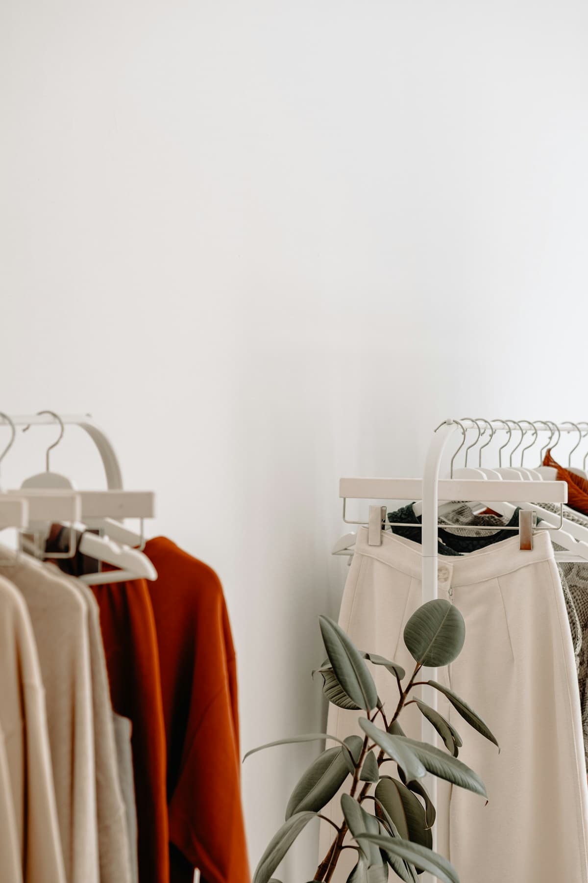 Clothes on white racks in a bright boutique
